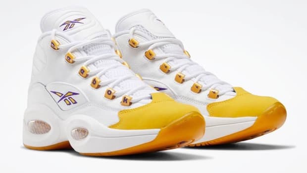 View of white and yellow Reebok shoe.